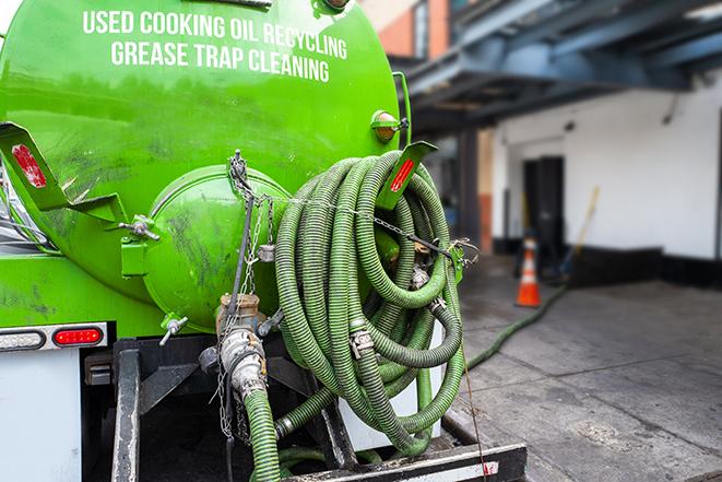 a technician pumping a grease trap in a commercial building in Wanatah, IN